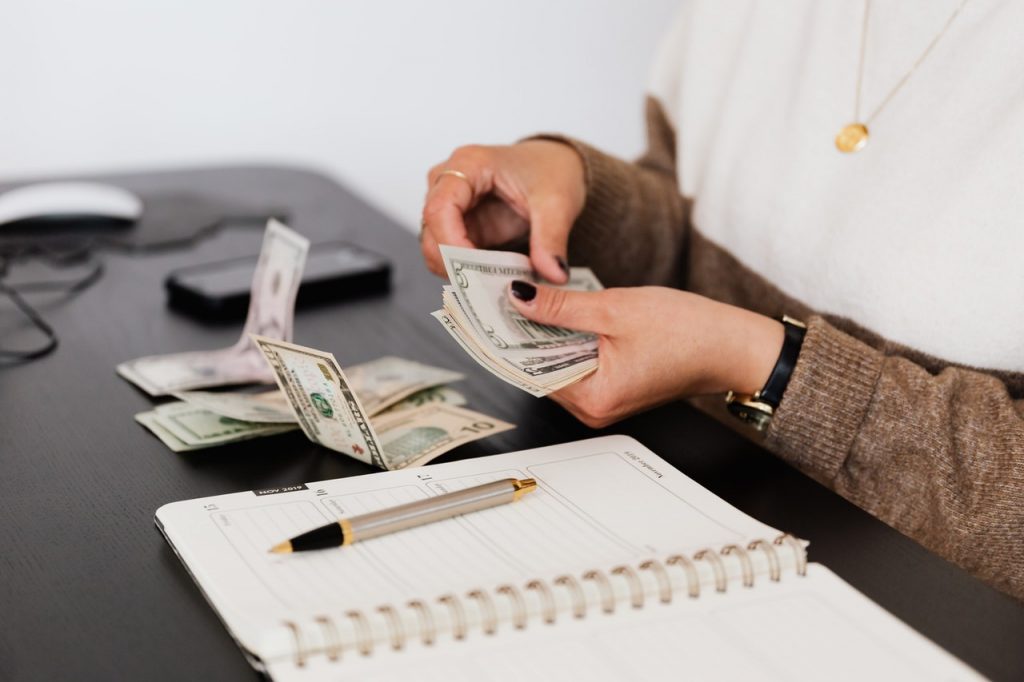 Persona contando dinero sobre un escritorio