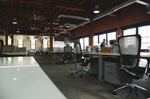 Espacio grande cerrado para oficina con gran numero de personas y mobiliario como escritorios y sillas