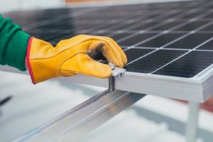 Hombre instalando un panel solar para generar energía eléctrica